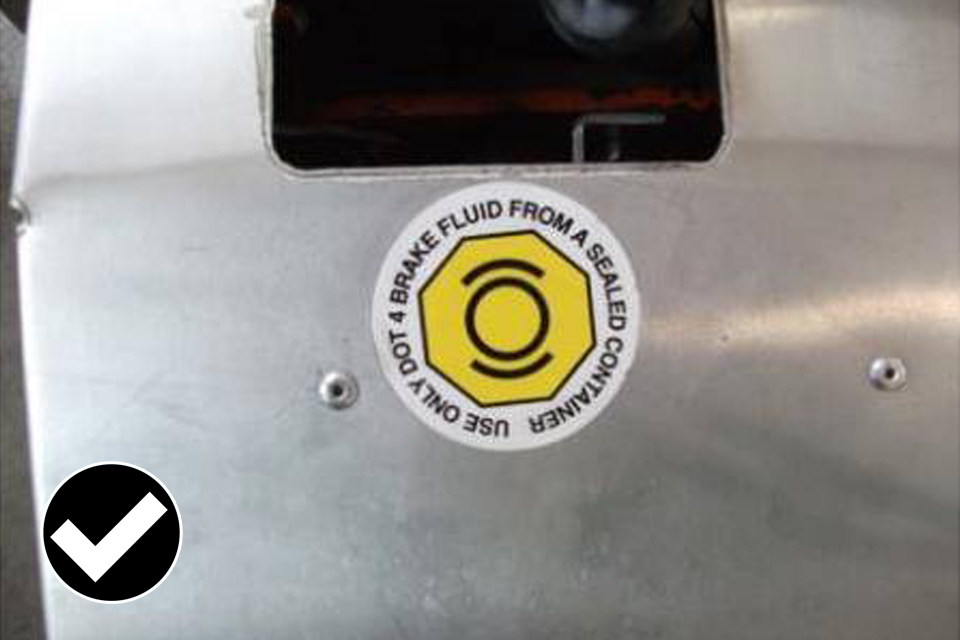 Allowed: indelible label fitted within 100mm of the master cylinder and identifies the brake fluid used.