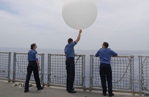 Able Seaman Kerry Woollard, Lieutenant Lee Newman and Leading Seaman Chris Edmonds release a weather balloon on board HMS Albion