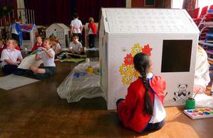A school girl painting a Wendy House