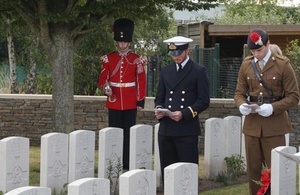 (l-r) Sub Lt Fred Warren-Smith, Military Attaché to the Defence Attaché The Hague and Lt Alexander Edmund from the Royal Regiment of Fusiliers pay their respects to 2 Lt Swallow as bugler LCpl Thomas Bewlay looks on, Crown Copyright, All rights reserved