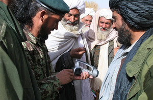 An Afghan soldier demonstrates a wind-up radio to a group of locals and elders in Helmand province (library image) [Picture: Crown copyright]