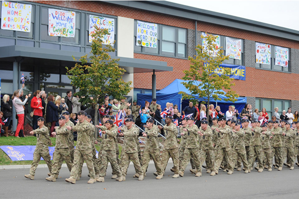 Families and loved ones cheer soldiers of the 19th Regiment Royal Artillery march into their barracks at Tidworth 