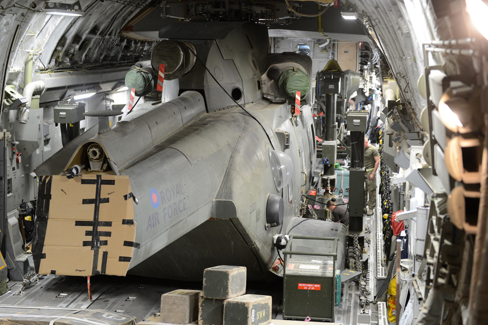 An RAF Merlin helicopter being packed and secured in a C-17 Globemaster aircraft