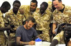 David Beckham signs autographs for soldiers from 67 Squadron, 6 Regiment Royal Logistic Corps, during his visit to Camp Bastion