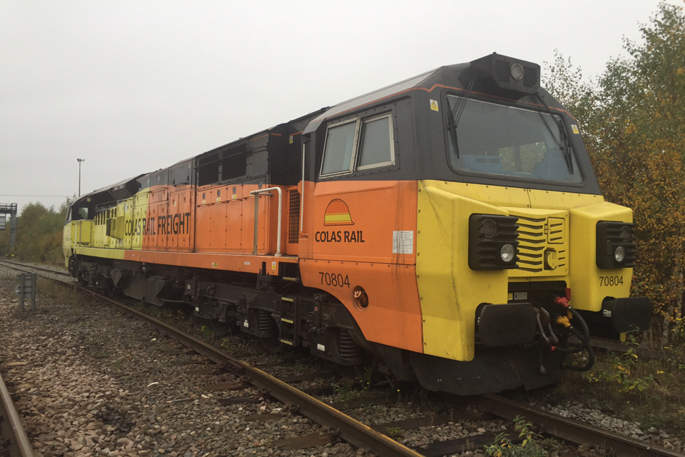 The derailed train in Colas Rail yellow and orange livery. The wheels on one side of the train are all in the cess, and the wheels on the other side are in the four foot (courtesy of Network Rail)
