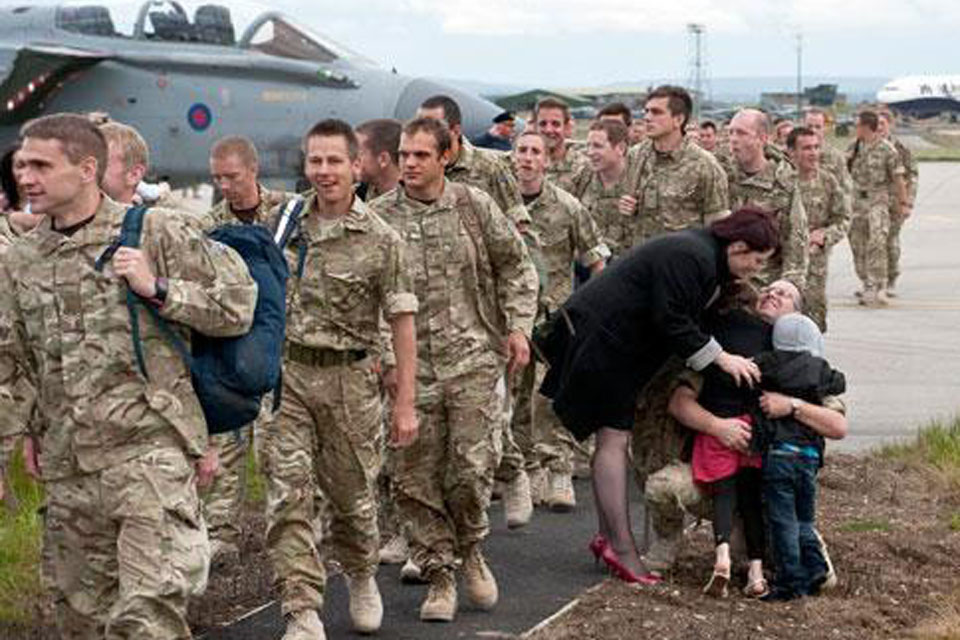An airman from 617 Squadron gets a warm welcome home from his family