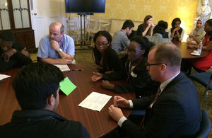 Students sitting around tables in discussion.