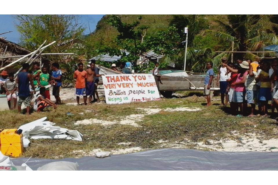 Philippine islanders hold up a sign of thanks