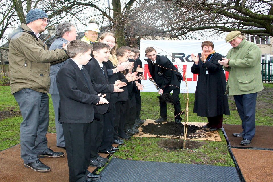 Pupils and staff planting a tree