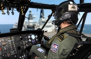 A helicopter pilot edges his aircraft closer to HMS Bulwark for landing during Operational Sea Training (OST).