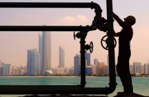 Worker closing pipeline valves against city background