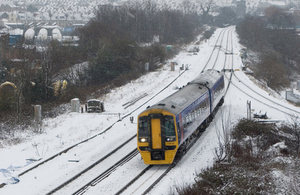 Train running through a landscape covered in snow.