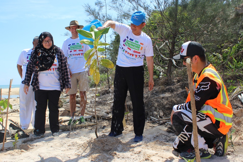 The Minister of Culture, Youth and Sports watering a sapling he had planted on Berakas Beach