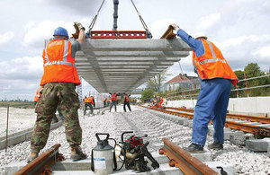 Workers laying rail track.