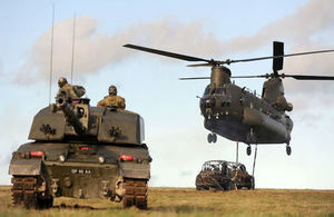 Shows a merlin helicopter and tank in shot together.