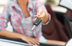 image of a woman holding a key in a car