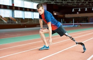 Athlete with prosthetic leg warming up on race track