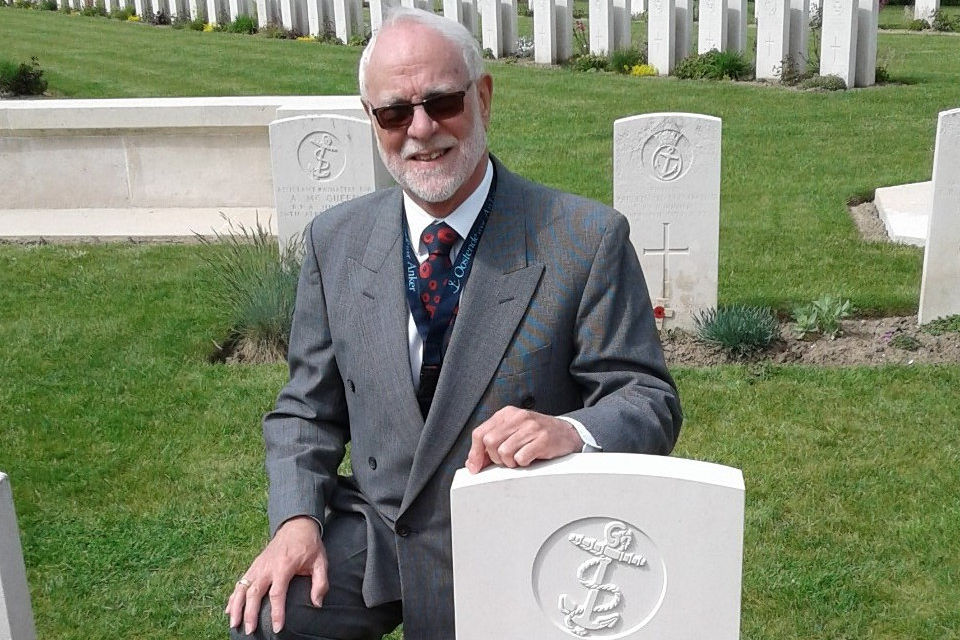 David Slade kneels beside the newly marked headstone for PO McDonald, Crown Copyright, All rights reserved