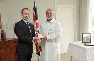 Mr Channu Pervaiz’ son, Aslam Pervaiz receiving the British Empire Medal from the British High Commissioner, Thoms Drew