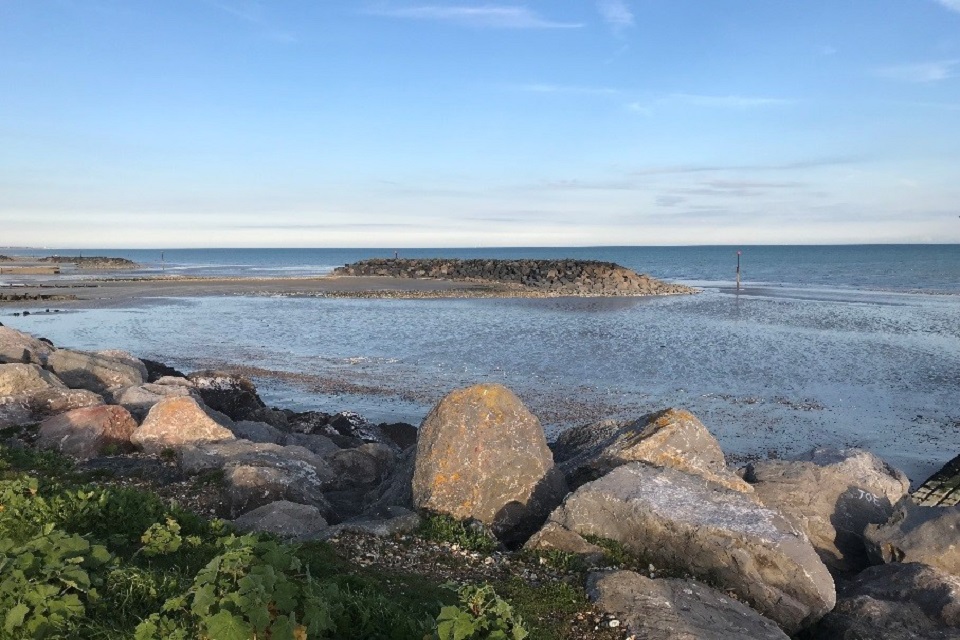 The shoreline view from Elmer at low tide. Offshore breakwaters and rock revetment. 