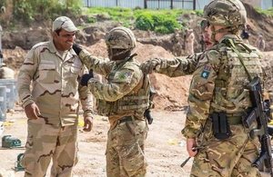 British Royal Engineers in military uniform discuss the construction of a bridge with an Iraqi security force (ISF) member in Mosul, Iraq.