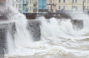Waves crashing against a sea wall (Credit: Getty Images)