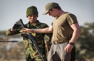 A female member of the Nigerian Air Force stands guard over a British soldier during a role play exercise run by the British Military Advisory Training Teams Short Term Training Team.