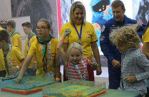 Baroness Sugg, Tim Peake and childrean learn about the surface of planets.