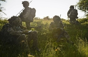 Four soldiers sitting in the grass.