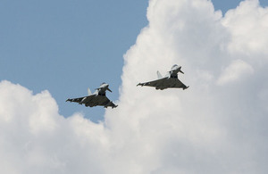 Two typhoons are flying against a blue sky.