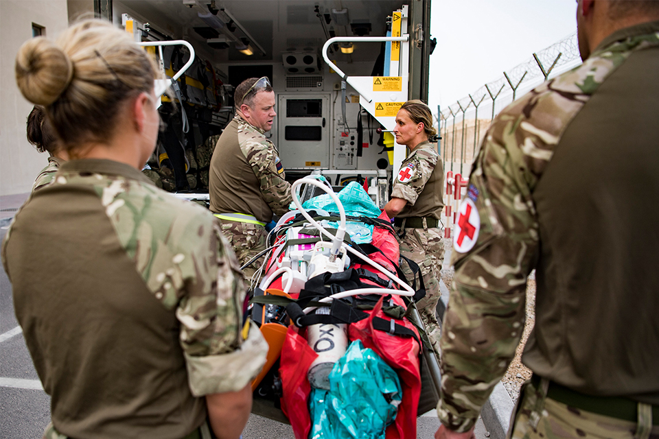 Members of the Joint Medical Group prepare to load a simulated casualty into an ambulance