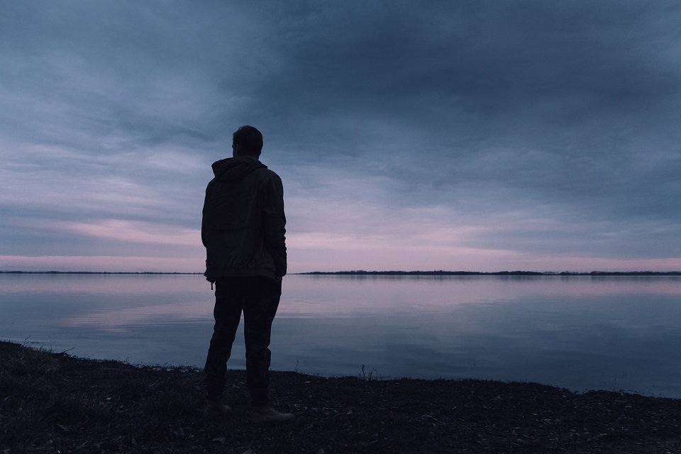 Silhouette of man standing at lake