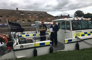 Two EA staff on their boat hold a trophy from the IWA