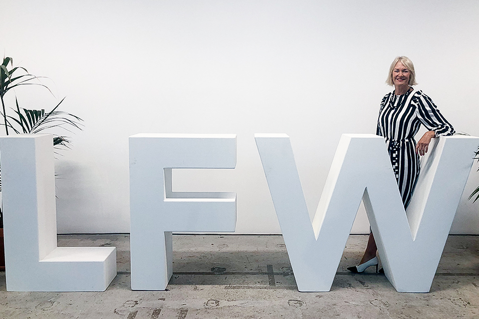 Image of the Minister for Digital and the Creative Industries in front of the London Fashion Week sign. 