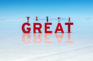 People jumping on GREAT letters on Bolivian salt flats