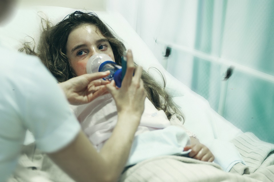 Young girl in hospital bed with respiratory problems