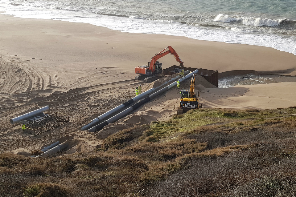 Large pumps set up on the beach at Loe Pool to pump water from Loe Pool and through Loe Bar and out to sea
