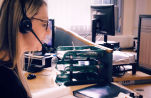 Woman sitting by desk with headphones