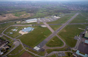 Aerial view of RAF Northolt. The runway can be seen surrounded by green fields.