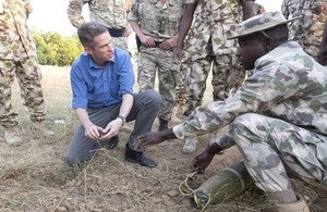 Defence Secretary Gavin Williamson speaks to a Nigerian soldier who is demonstrating how to detect and diffuse an improvised explosive device.