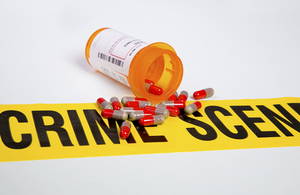 bottle of split pills over crime scene tape