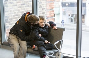 Father giving his son a hug in a doctors' waiting room.