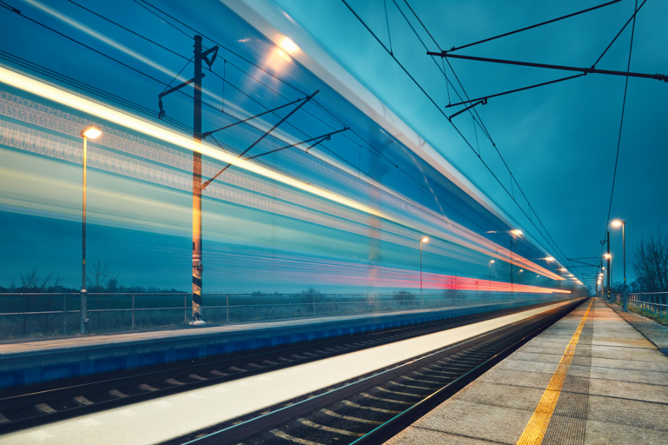 Light trail of a train passing through a station at night (credit: Chalabala/iStock ID:904833938)