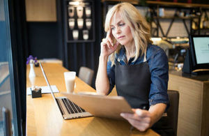 Image of coffee shop owner using a laptop