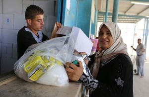 A Palestine refugee woman receives food assistance at the UNRWA Khan Younis Distribution Centre in Gaza in 2016. Picture: UNRWA/Tamer Hamam