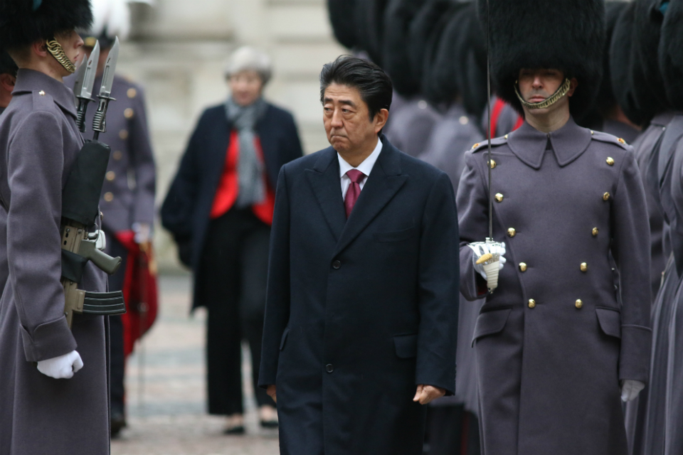 Japanese PM walking along a row of soldiers