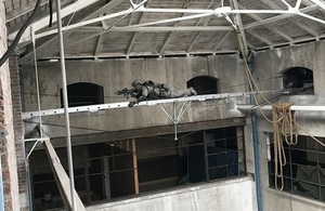 Bridge suspended from one wall to another with a soldier on top