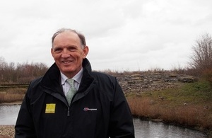 Natural England Andrew Sells standing in front of a pool of water