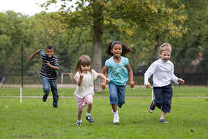 Four children running in a park