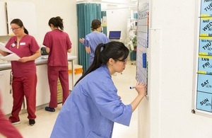 A nurse updating a whiteboard in a hospital.
